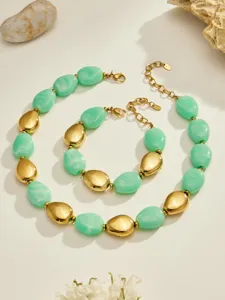 Vue détaillée d'un ensemble collier et bracelet en résine verte et métal doré, design élégant.