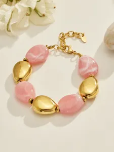Gros plan détaillé du bracelet élégant en résine rose et perles métalliques dorées, beau design.