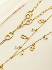 Close-up of elegant gold stainless steel Y-shaped tassel necklace with pearl pendants.