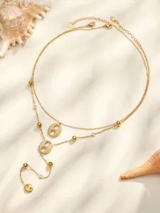 Collier lariat double couche avec pendentifs géométriques pavés de zircon et pompons en acier.