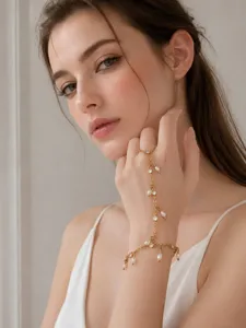 Vista detallada del pulsera esclava dorada con perlas delicadas y cristales brillantes.