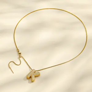 Colgante de letra K de acero inoxidable chapado en oro con detalles de circonita.