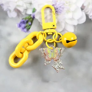 Dettaglio del portachiavi a farfalla gialla alla moda con catena colorata e campanello.