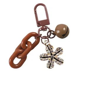 Chic brown chain keychain featuring a sparkling rhinestone flower pendant and cute bell.