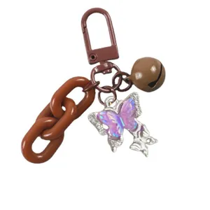 Portachiavi con farfalla colorata, catena marrone e campanello, accessorio moda versatile.