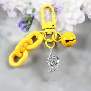 Sleutelhanger detail met gele grove ketting, schattig belletje en sprankelende kristallen hanger.