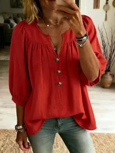 Vista dettagliata di camicetta rossa casual da donna con scollo a V, bottoni e maniche.