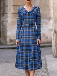 Nahaufnahme Details des blauen karierten Langarmkleides mit elegantem Wasserfallkragen.