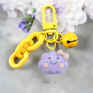 Dettaglio portachiavi nuvola viola con catena gialla, gancio e campanella in stile kawaii.