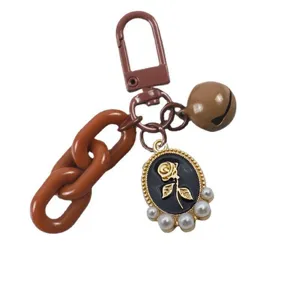 Chic brown keychain bag charm with oval black rose cameo and pearl accents for daily use.