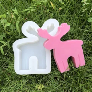 Detalle de molde de silicona y reno rosa para velas navideñas y manualidades creativas.