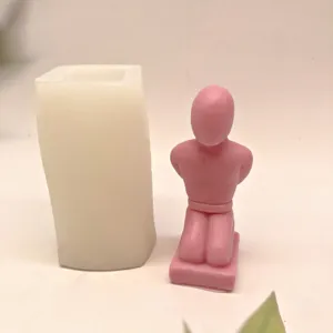 Silicone mold and pink kneeling human candle set for DIY craft and aromatherapy use.