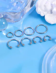 Nahaufnahme Detailansicht von 8 Stueck 16G Edelstahl Koerper Piercingringen und Hufeisenstiften.