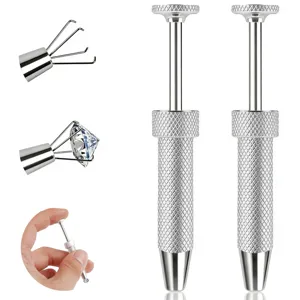 Detail de l'outil de prehension de diamants a quatre griffes et boucles d'oreilles inox.