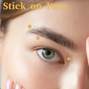 Primer plano detallado de pegatinas de gemas doradas para efecto de piercing en la ceja.