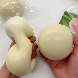 Nahaufnahme einer Hand, die ein weißes, weiches Käse-Daifuku-Stressspielzeug drückt