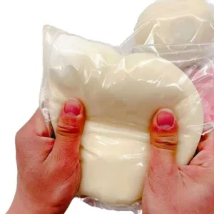 Nahaufnahme von Händen, die ein großes weißes Squishy-Spielzeug zum Stressabbau drücken