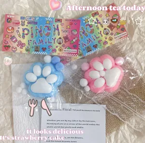Makrodetail von blauen und rosa beflockten Katzenpfoten-Squeeze-Spielzeugen in süßer Verpackung