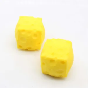 Detalle de dos grandes juguetes antiestrés amarillos con forma de queso cuadrado