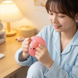 Nahaufnahme einer Person, die ein rosa Glitzer-Squishy-Spielzeug zum Stressabbau drückt