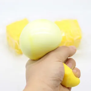 Gran juguete antiestrés de queso simulado en forma de cubo siendo apretado por una mano humana