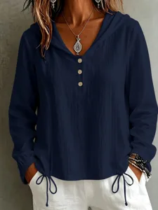 Vista dettagliata di una elegante camicia a maniche lunghe con cappuccio blu scuro.