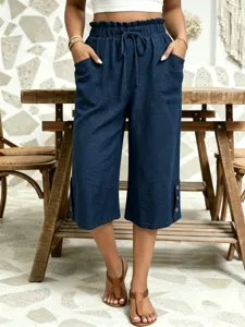 Detailed view of women's casual loose dark blue cotton linen cropped trousers with elastic waist.