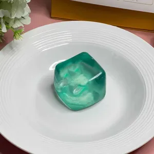 Nahaufnahme eines lichtdurchlässigen grünen Eiswürfel-Quetschspielzeugs zur Entspannung