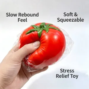Eine Hand drückt ein realistisches rotes Tomaten-Squishy-Spielzeug zum Stressabbau