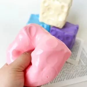Nahaufnahme von rosa Käse Squishy Spielzeug wird zum Stressabbau gedrückt