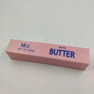 Nahaufnahme eines rosa Butter-Squishy-Spielzeugs mit blauem Textaufdruck für den Stressabbau
