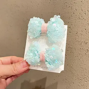 Dettaglio di mollette per capelli con fiocco di paillettes per bambini, accessori dolci.