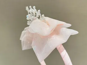 Detailed view of kids pink hair hoop with pearl crown and tulle bow, sweet fairy princess style.