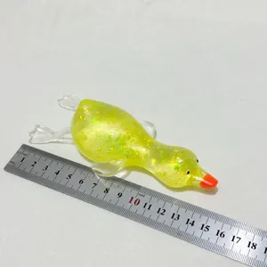 Detaillierte Maßstabsansicht von gelbem Glitzerenten-Squishy neben einem Profi-Metalllineal