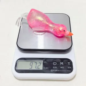 Nahaufnahme eines rosa Glitzer-Enten-Quetschspielzeugs auf einer Waage mit 97,2 g.