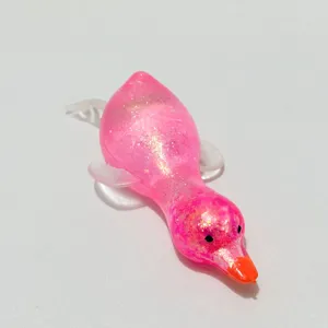 Nahaufnahme eines rosa glitzernden Enten-Quetschspielzeugs mit elastischer Textur