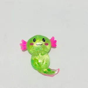Nahaufnahme eines glitzernden grünen Axolotl-Squishy-Spielzeugs zum Stressabbau