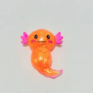 Detailansicht eines glitzernden orangefarbenen Axolotl-Quetschspielzeugs mit süßem Design