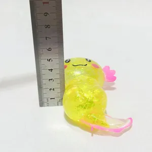 Makroansicht eines gelben Glitzer-Axolotl-Quetschspielzeugs mit Lineal für 6 cm Größe