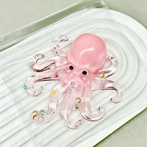 Pink octopus squishy toy with pearl and star decorations in packaging