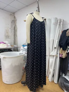 Detail shot of black strap long dress with white heart print, displayed on mannequin in studio.