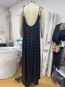 Detailed view of the black backless long slip dress featuring allover white heart print.