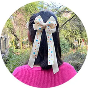 Cream white polka dot hair bow with long ribbons, sweet children hair clip detail.