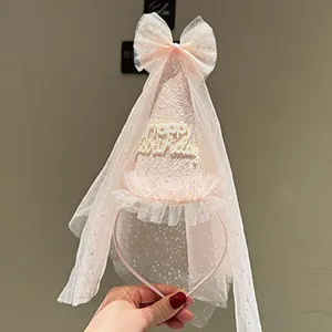 Close-up detail of the pink tulle birthday hat headband, featuring a cute bow and party design.