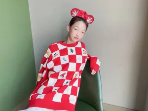 Nahaufnahme Detail des weihnachtlichen roten Minnie Maus Ohr Haarreifs und Karo Pullovers.