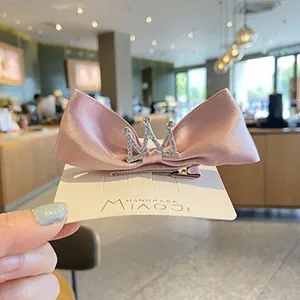 Pink satin bow hair clip with crystal crown for cute baby girls, handmade hair accessory.