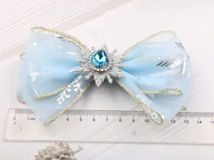 Detailaufnahme der blauen Schneeflocken Schleife mit Kristall Strass Mitte und Organzaband.