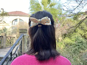 Detail shot of a cream white polka dot hair bow clip, perfect for lovely children daily styling.