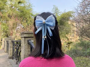 Dulce horquilla japonesa de lazo de encaje azul claro con perlas y borlas colgantes.