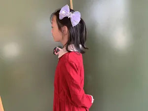 Reizende violette Mesh-Haarschleife mit Schneeflocken und Edelsteinen, seitlich am Kindermodel.